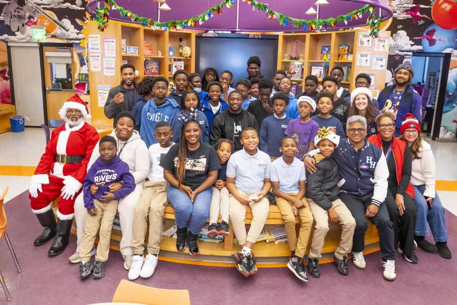A large group photo of students and teachers with Roquan Smith of the Baltimore Ravens