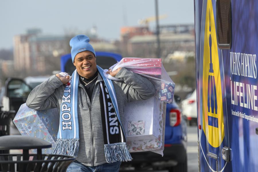 A Johns Hopkins affiliate carries bags of presents
