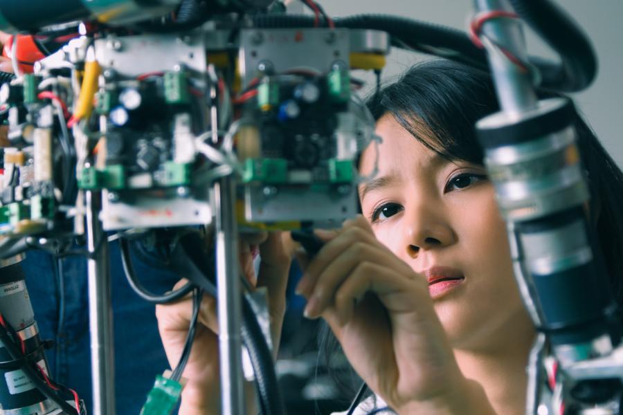 A high school student works with equipment in an engineering lab