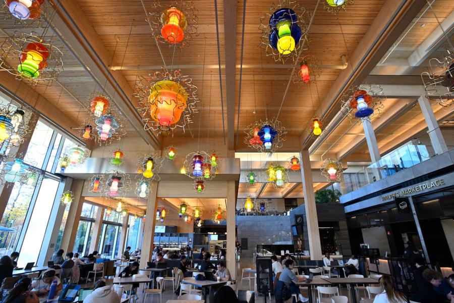 Multiple colorful light fixtures hang overhead in the food hall at the Bloomberg Student Center