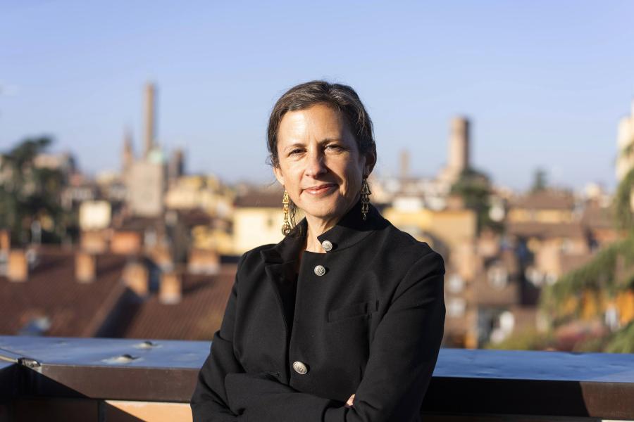 A woman in black attire poses for a portrait in an outdoor setting