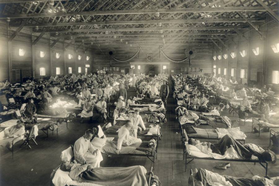 Doctors and nurses tend to the sick in an aged photograph
