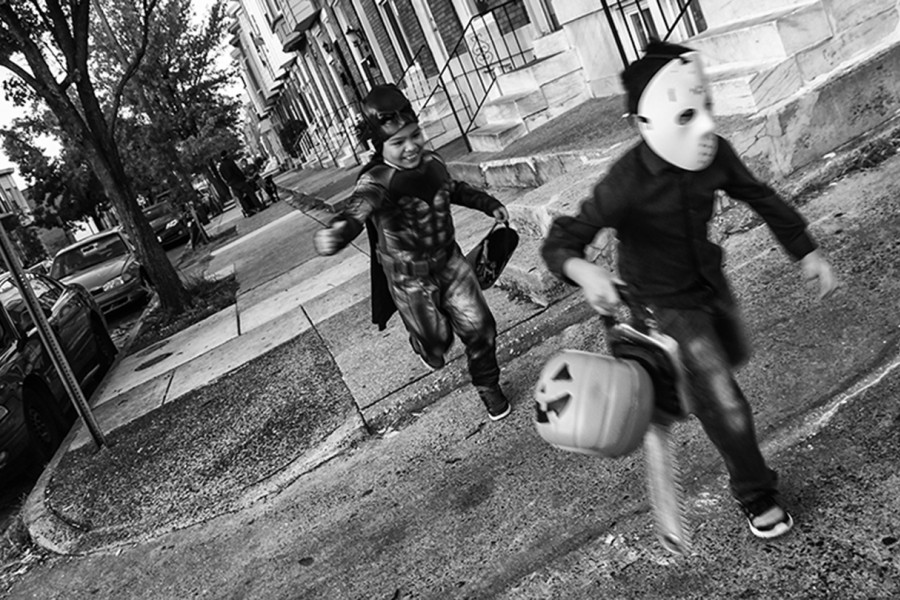 Two boys run in Halloween costumes