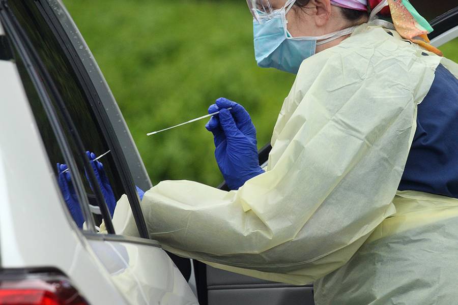 RN Mindy Bell takes a nasal swab at a drive-through COVID-19 testing center at Johns Hopkins Bayview