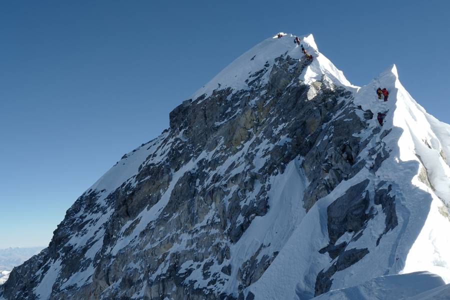 Climbers climb a mountain ridge over Everest