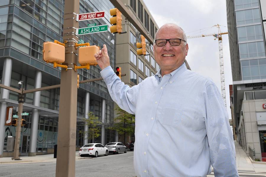 John Hundt posing in front of his new ceremonial street sign 