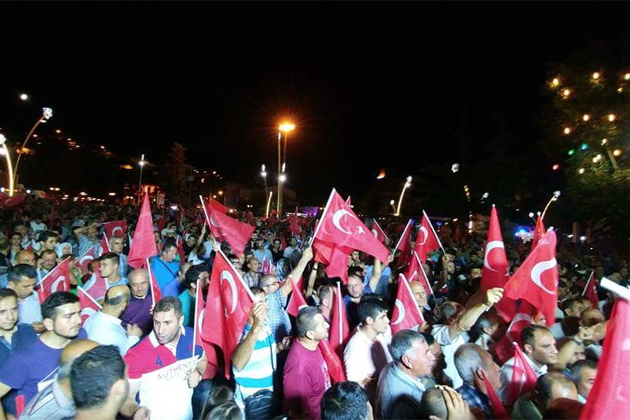 Turkish people wave flags and assemble to protest the military coup
