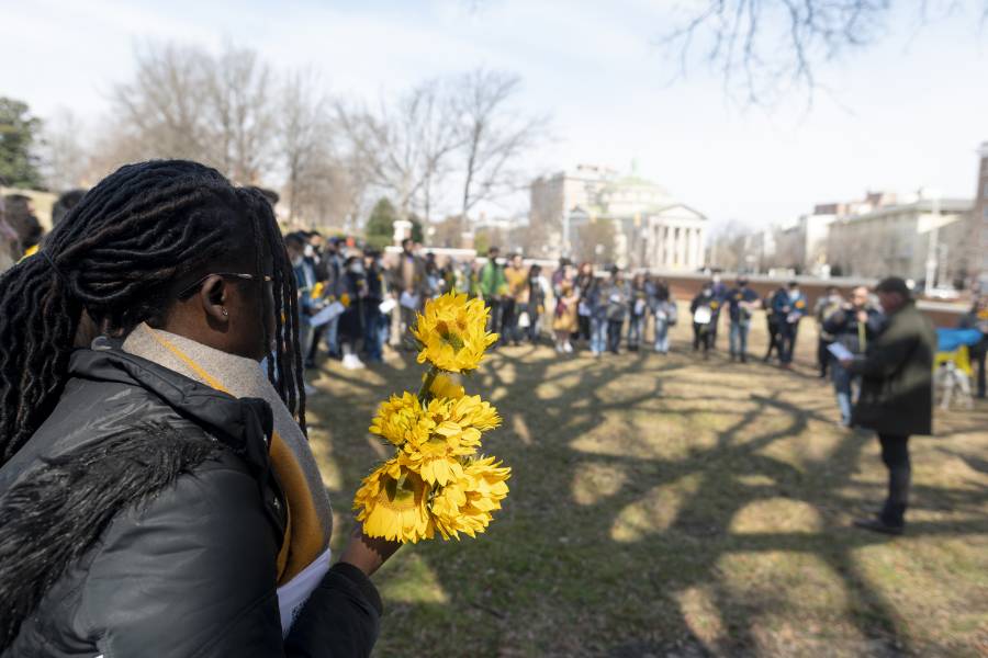 A person holds sunflowers at a vigil in support of Ukraine