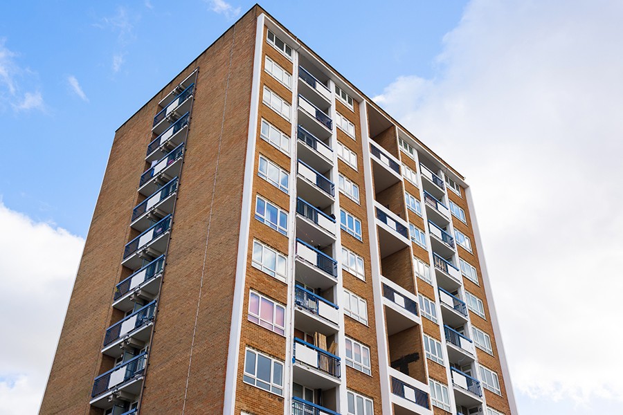 High-rise apartment building against a bright blue sky