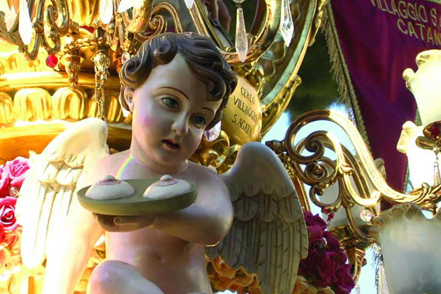 A statue of a cherub holds a platter with two amputated breasts on it