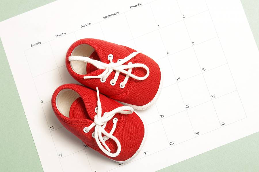 Red baby sneakers on a monthly calendar