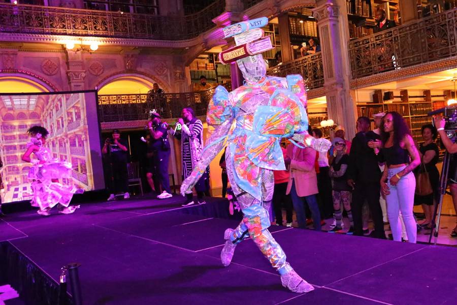 Ballroom performer in book costume struts on the catwalk