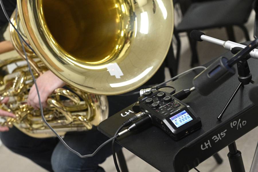A player plays the baritone while various recording devices record