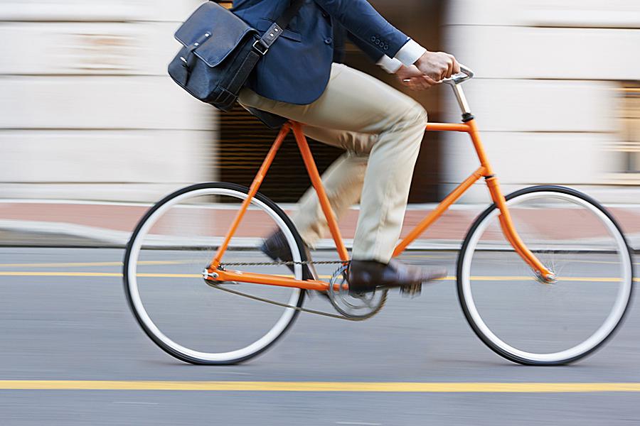 man in business clothes riding a bike