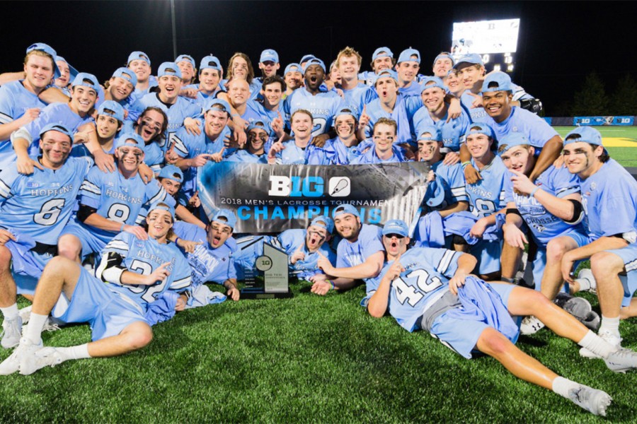 Hopkins mens lacrosse team poses with 2018 Big Ten Conference championship banner