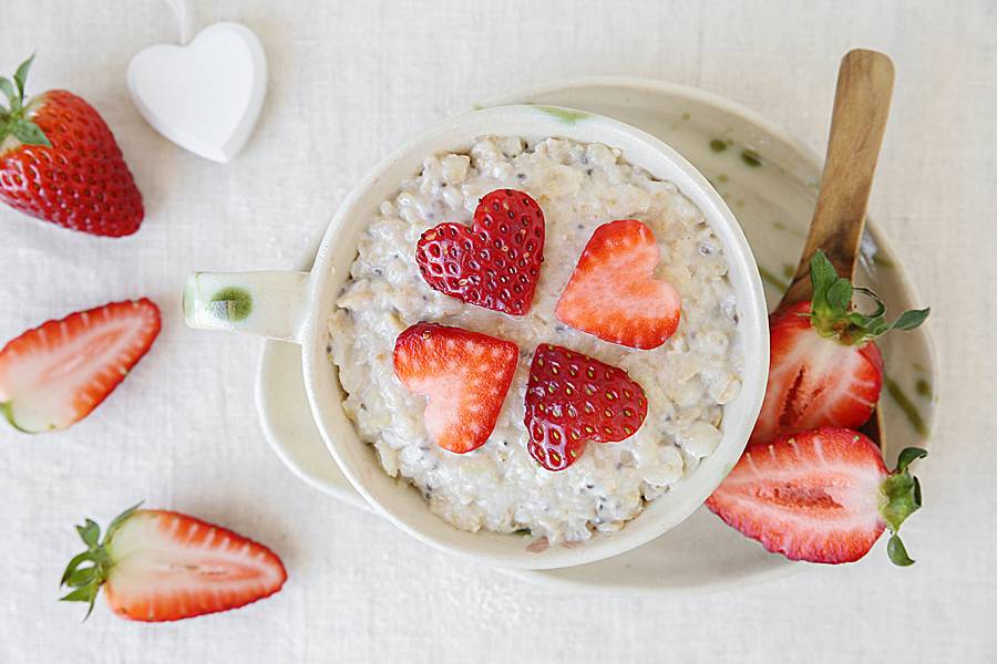 Heart-shaped strawberry slices atop a bowl of oatmeal