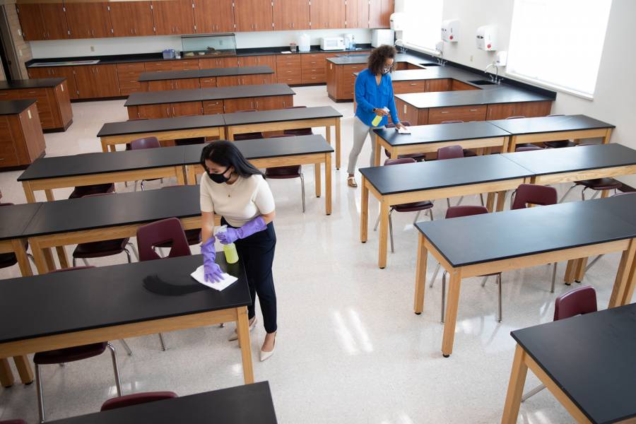 Two instructors clean a laboratory classroom