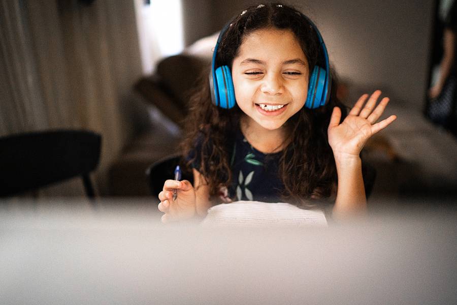 Young girl at computer wearing headphones