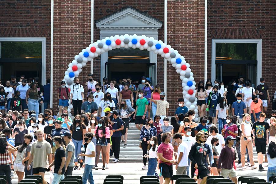 Students walk out of Shriver Hall under red, white, and blue balloon arch on Democracy Day