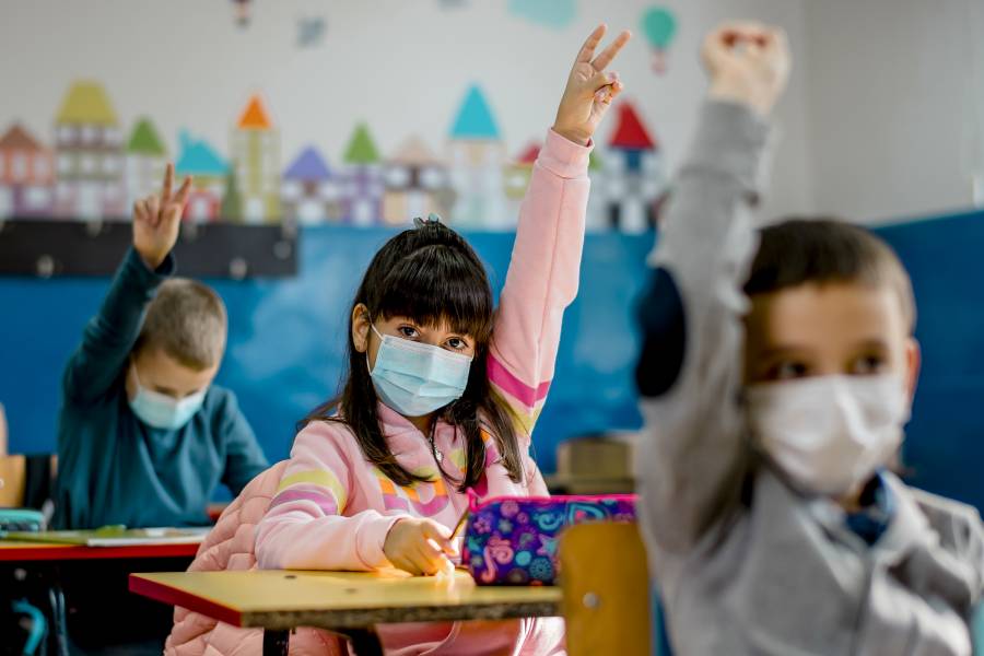 Masked children in a classroom