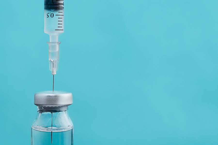Closeup of a needle drawing vaccine from a vial