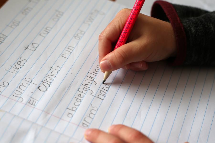 Un niño escribiendo a mano.