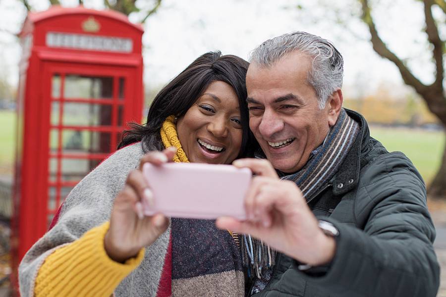 Senior man and woman taking selfie in a park