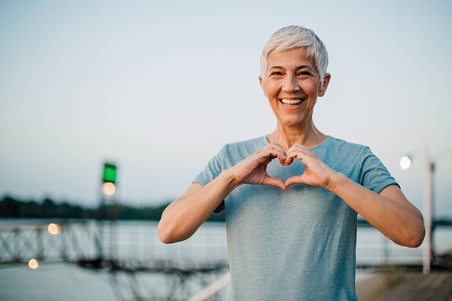 Active older woman making a heart with her hands