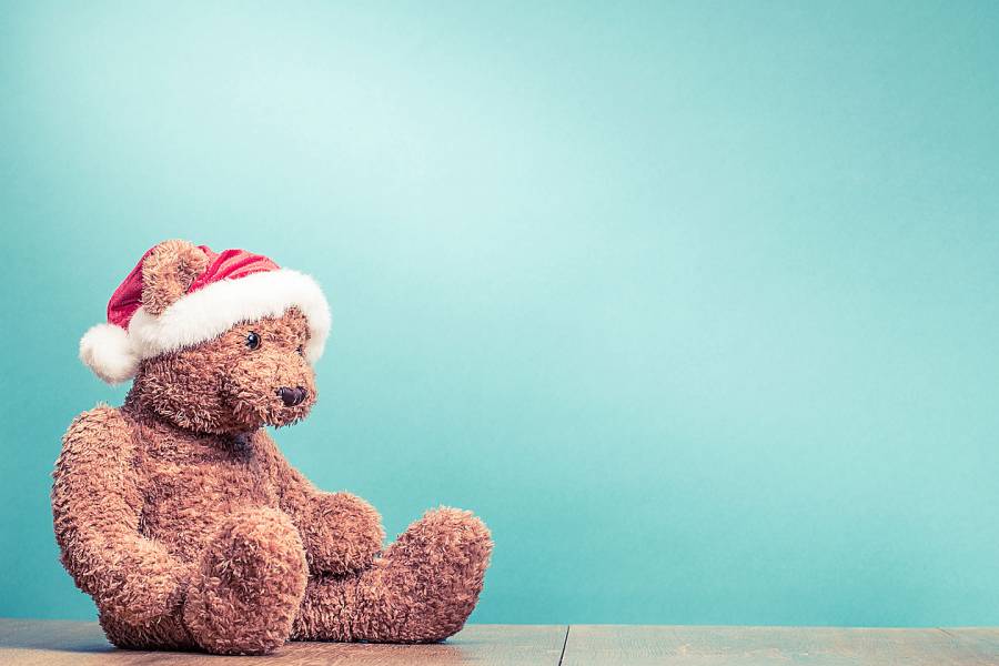 Sad-looking teddy bear wearing a Santa hat
