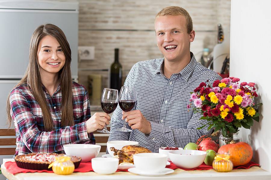 Happy young couple having holiday dinner alone in their kitchen