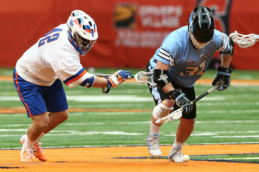 Two lacrosse players battle for a ground ball