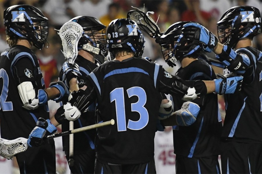 Hopkins lacrosse players in black uniforms with blue numbers