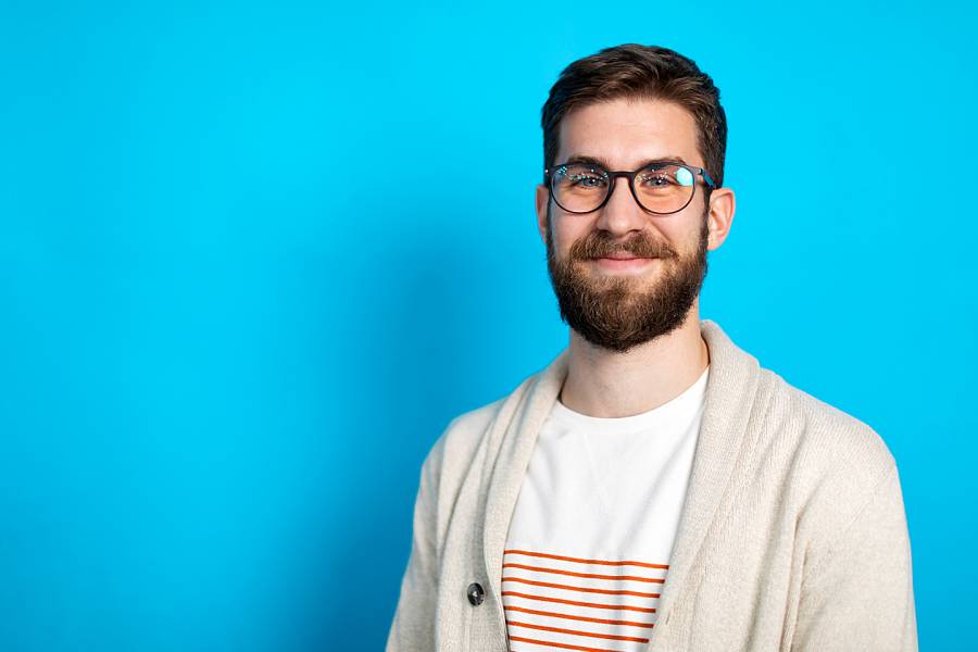 Smiling young male office worker with glasses and a beard