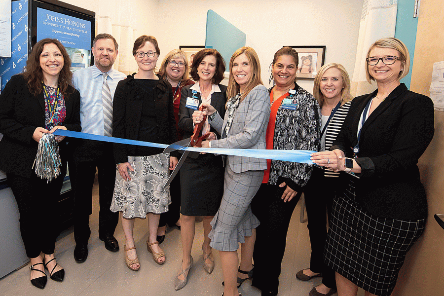 An HR team cuts the ribbon on the new mother's room