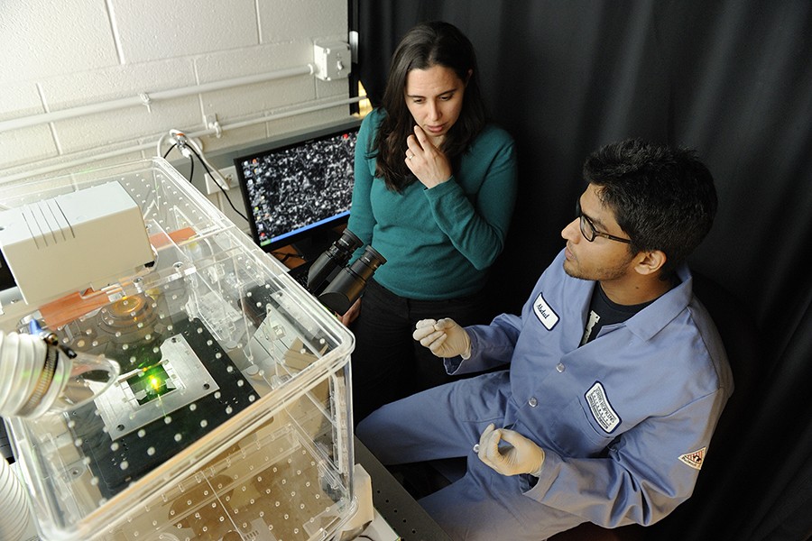 Researchers sit next to a a single-molecule fluorescence microscope