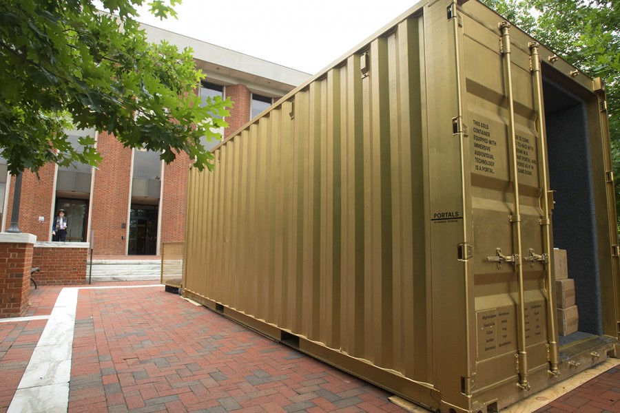 Gold shipping container in front of brick academic building