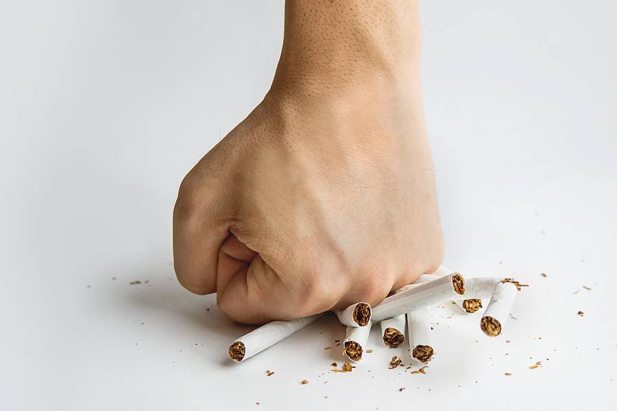 Man’s fist crushing cigarettes
