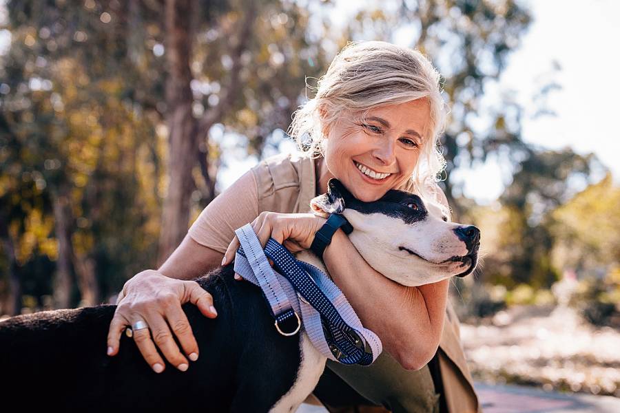 Smiling senior woman hugging dog