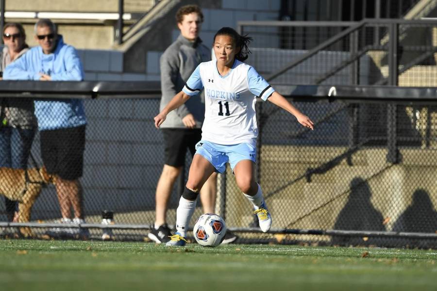 Johns Hopkins women's soccer player dribbles