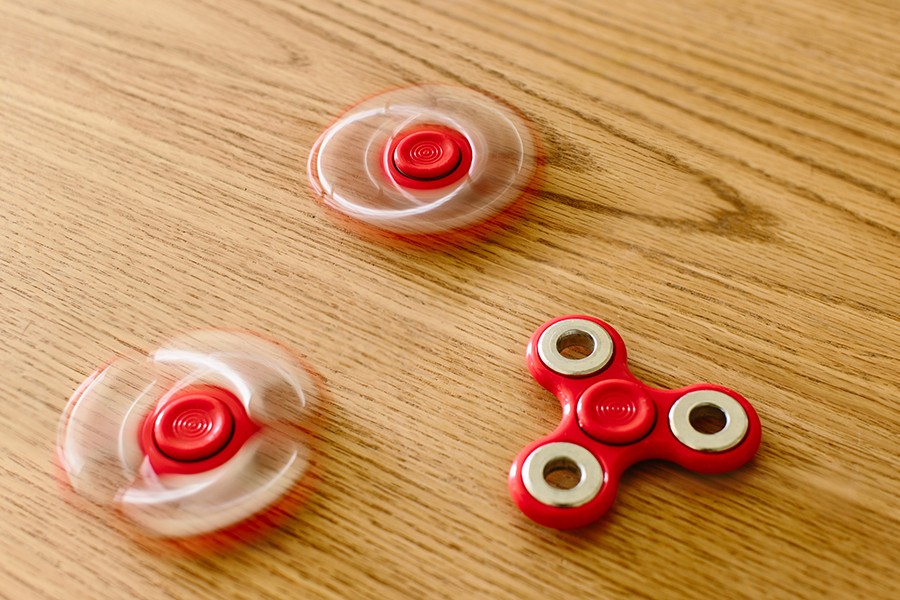 Three red spinners on a wooden table