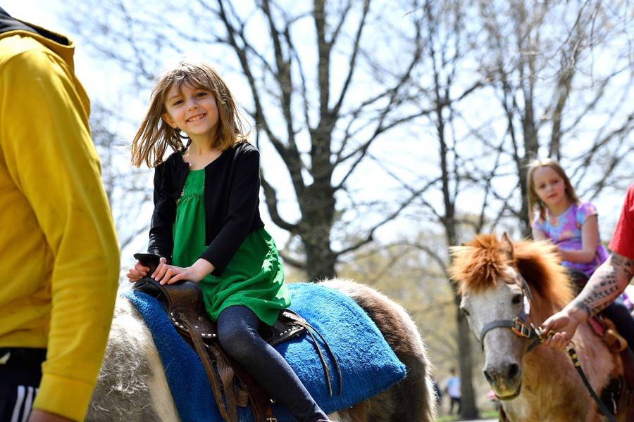 Little girl rides a pony at Spring Fair