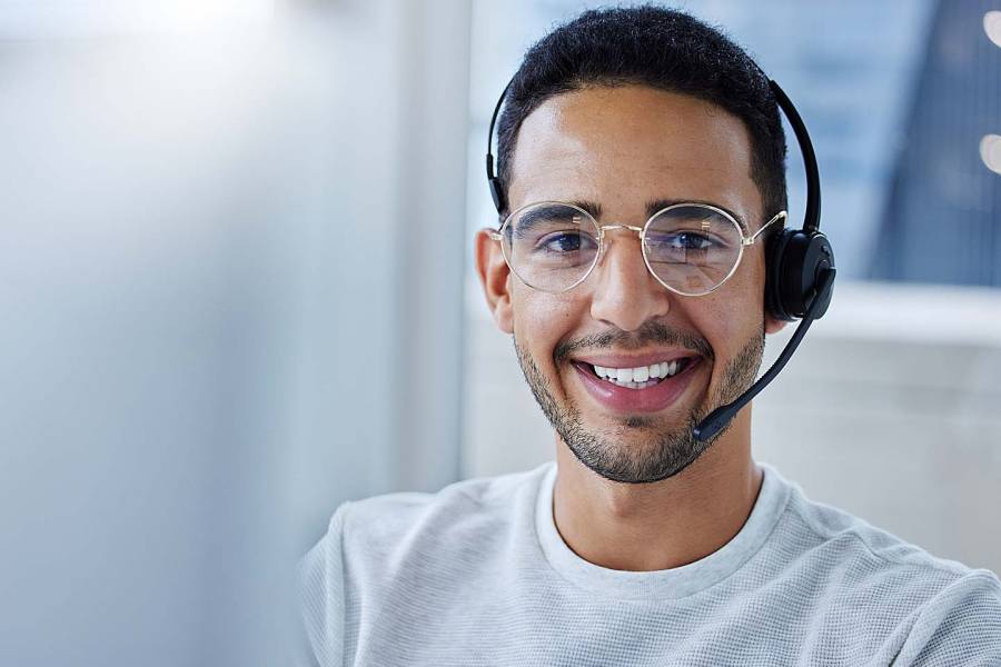 Young man wearing a telephone headset and talking with a customer