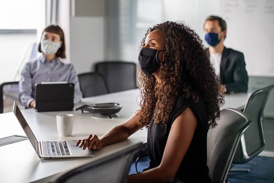 People wearing masks meeting in an office