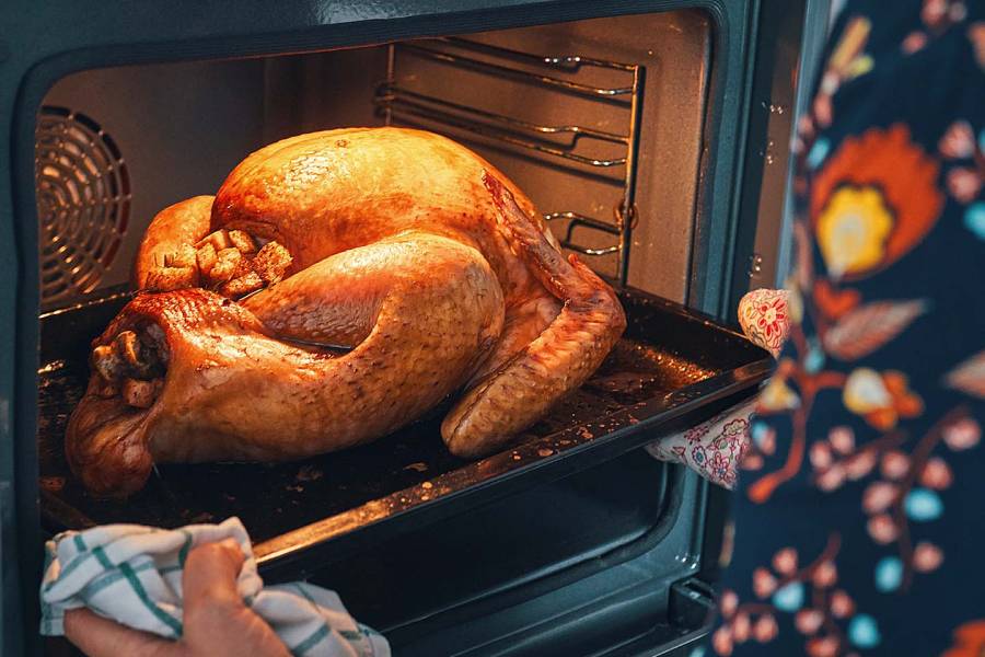 Perfectly roasted turkey being removed from the oven