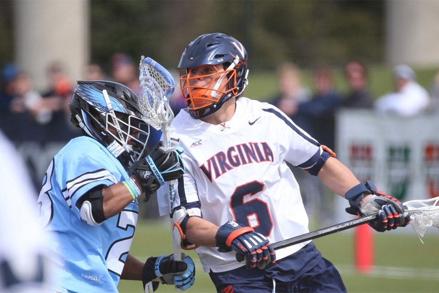 A Virginia lacrosse player goas to the goal against a Hopkins defender