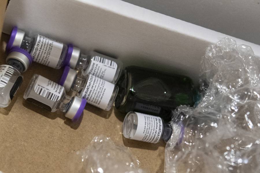 Empty vaccine vials are discarded in a cardboard box