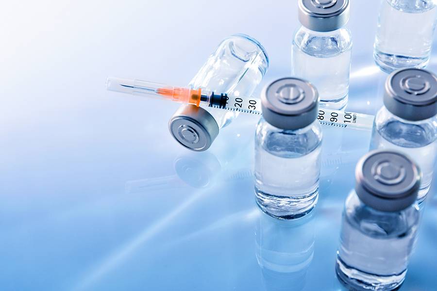 Vaccine vials and a syringe