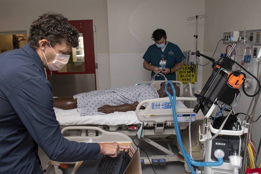 Two scientists test a robot in an ICU simulation room