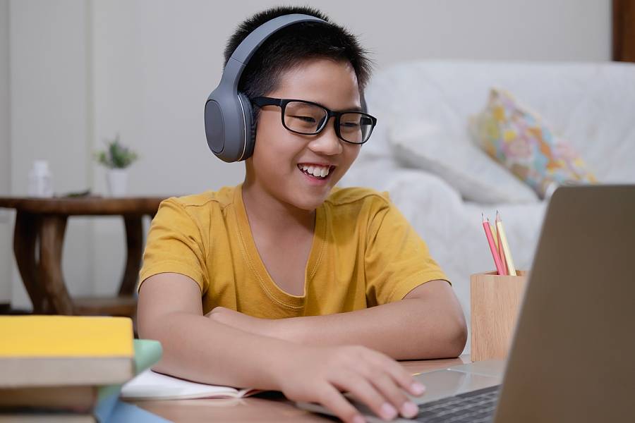 Young boy wearing headphones and working on computer