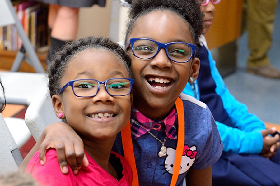 Two little girls smile in brand new glasses